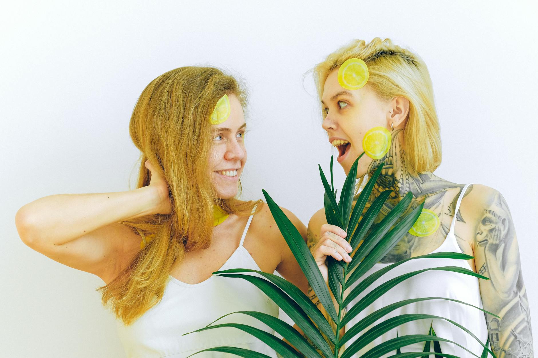 Two women smiling while holding fresh lemons, expressing joy and confidence about pleasure at any age