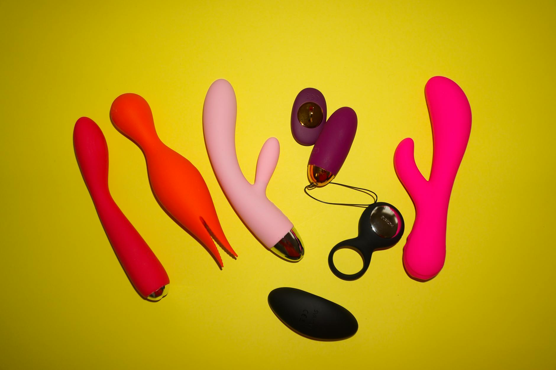 Hand holding a vibrator against a purple background, showcasing modern sensuality and pleasure